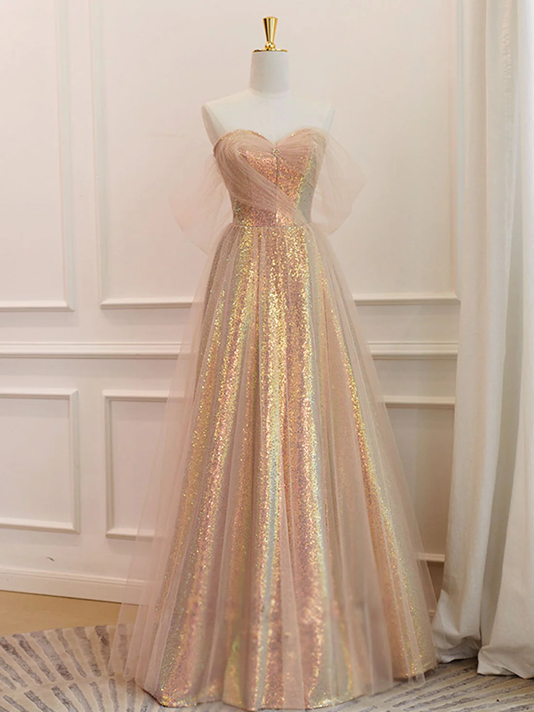 Robe de bal longue à paillettes dorées et décolleté en cœur