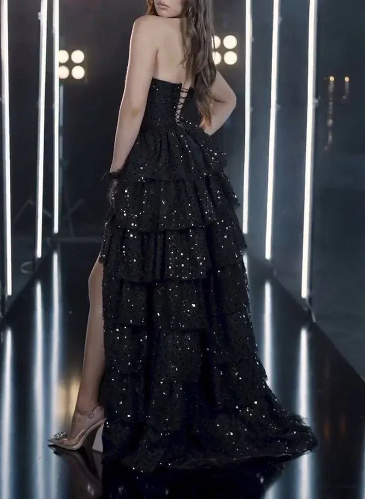 Close-up of the tiered ruffle tulle skirt and elegant side slit of the black sequin prom dress.