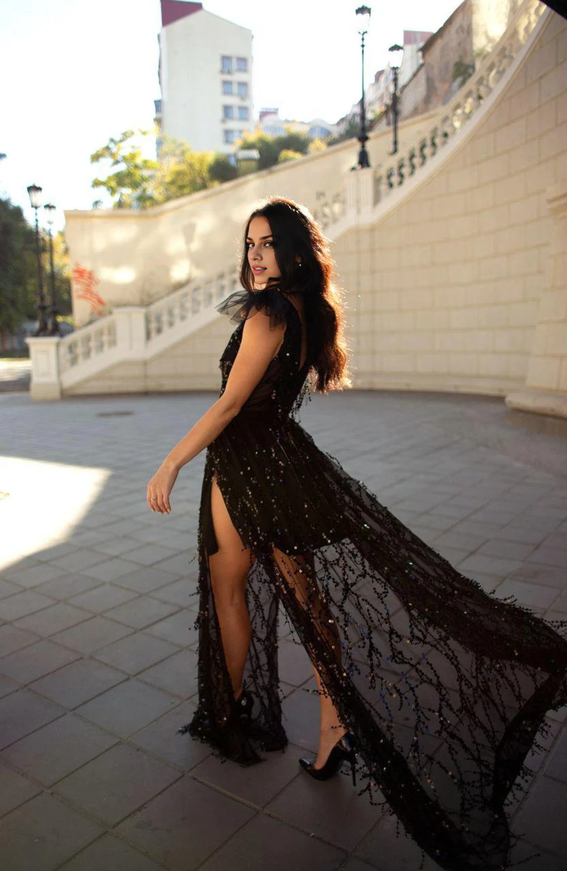 Robe de soirée noire longue à paillettes avec fentes sur les jambes et empiècement transparent dans le décolleté. Robe de bal 