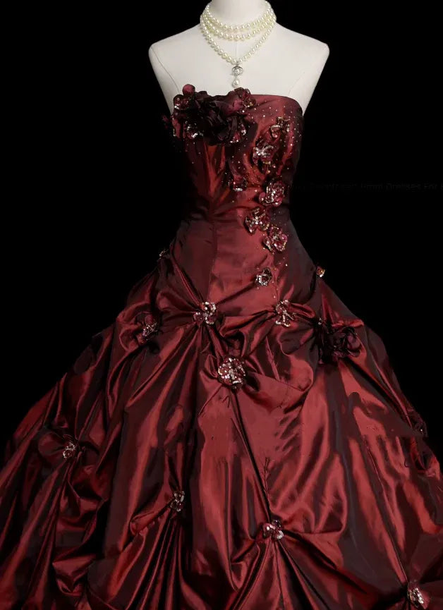 Close-up of the floral appliques and rhinestone details on the burgundy gown.