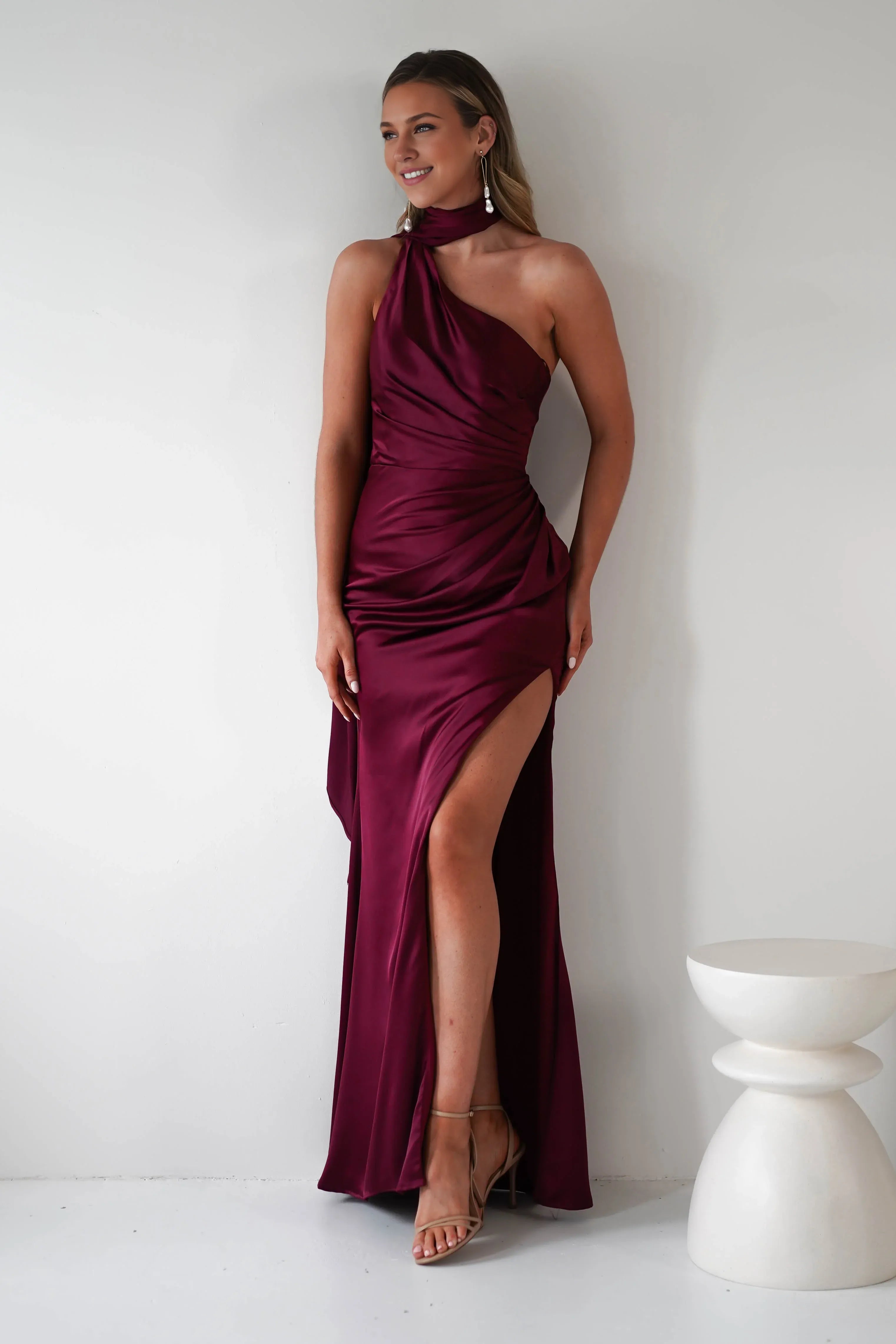 Robe Weitese en satin bordeaux, asymétrique, décolleté licou, corsage froncé en satin et fente haute spectaculaire. 