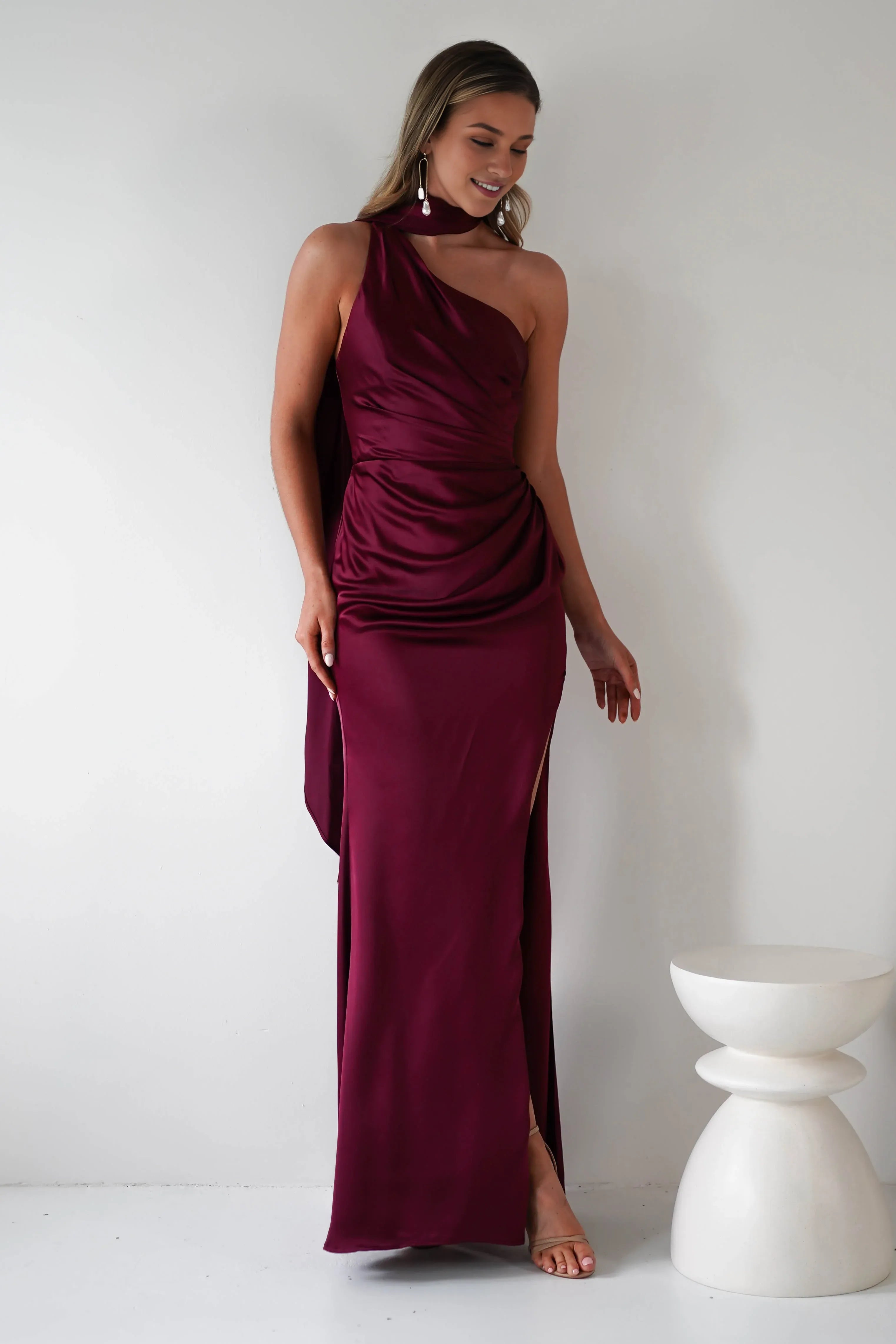 Robe Weitese en satin bordeaux, asymétrique, décolleté licou, corsage froncé en satin et fente haute spectaculaire. 