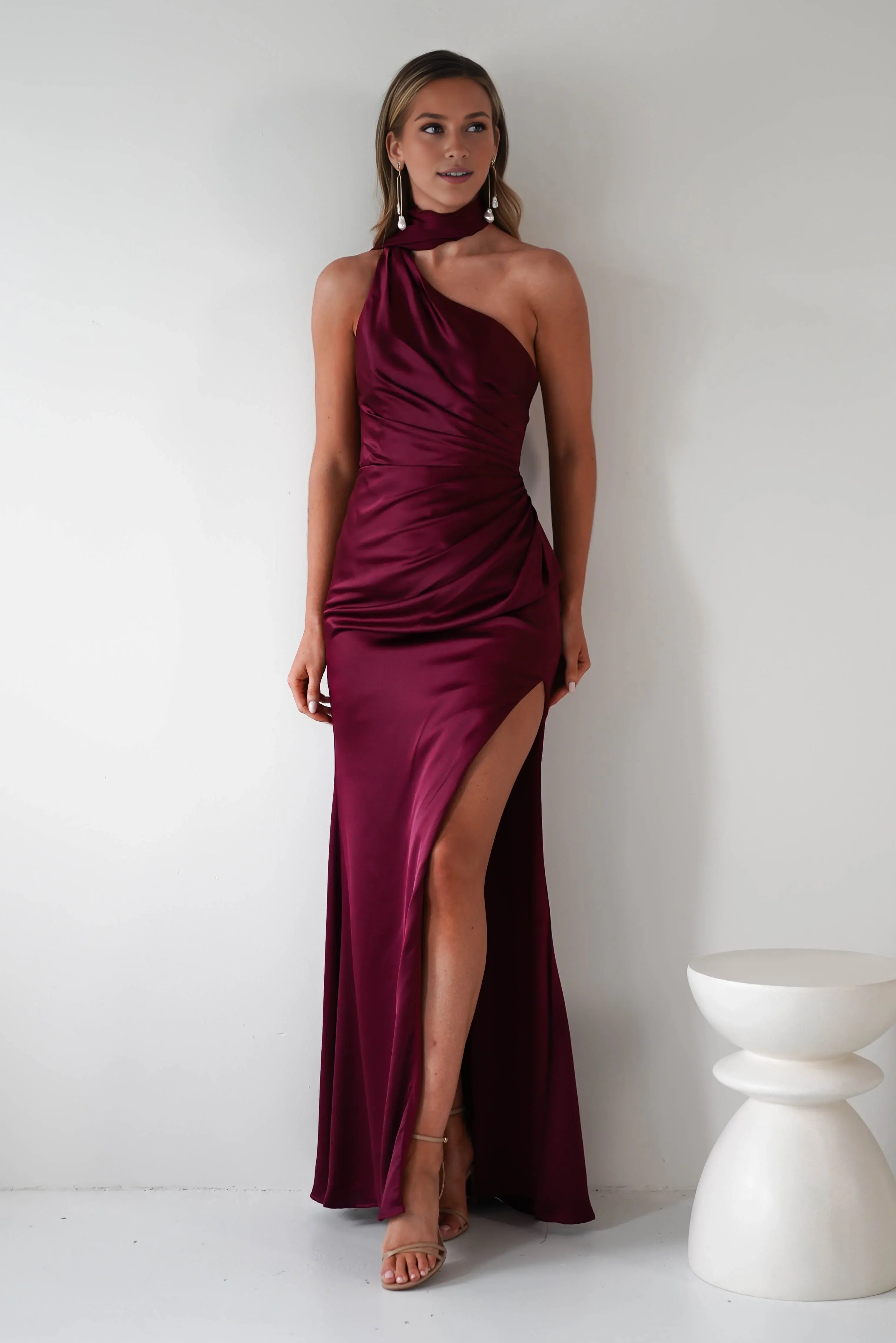 Robe Weitese en satin bordeaux, asymétrique, décolleté licou, corsage froncé en satin et fente haute spectaculaire. 