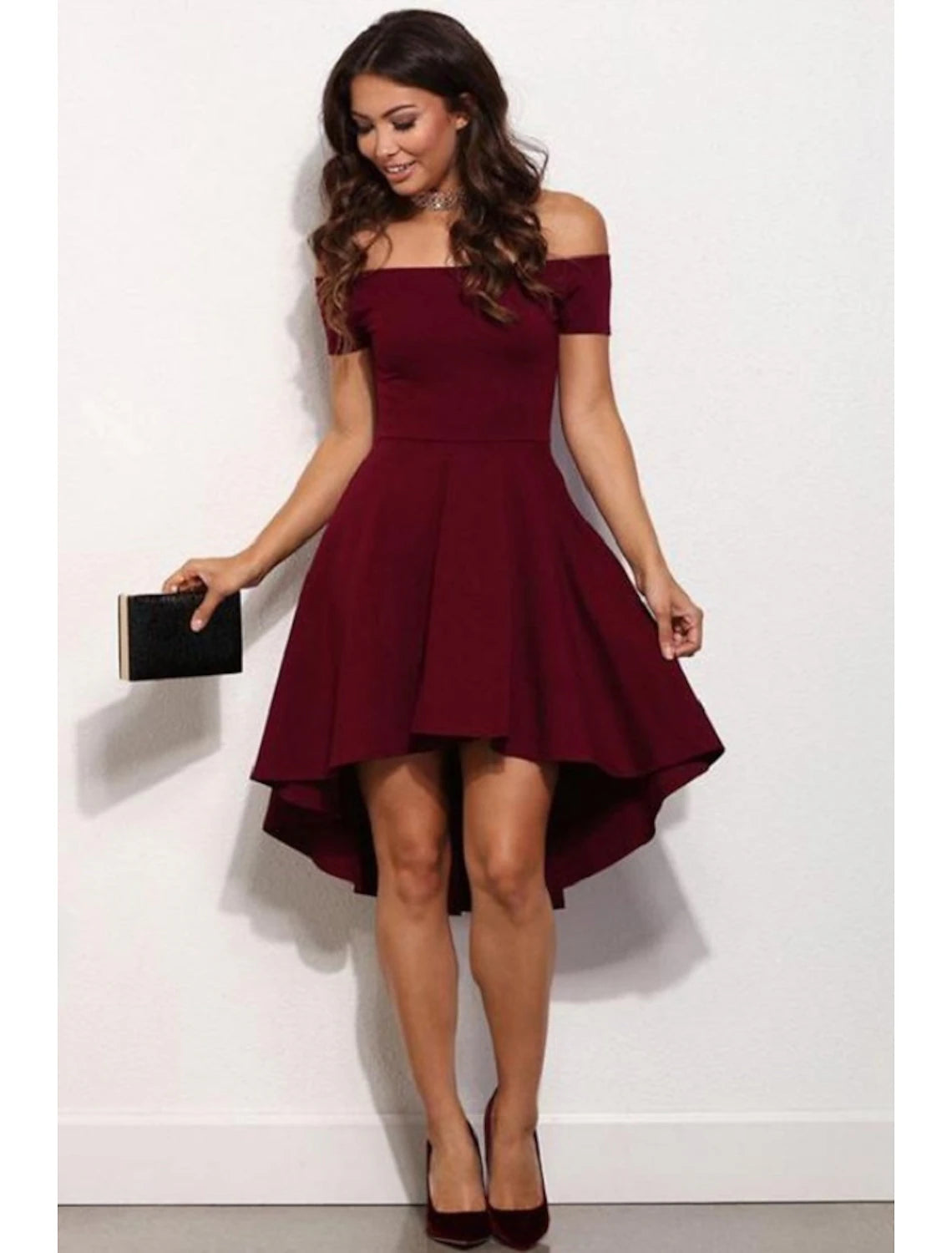 Front view of a woman in a light pink A-line off-shoulder mini dress.