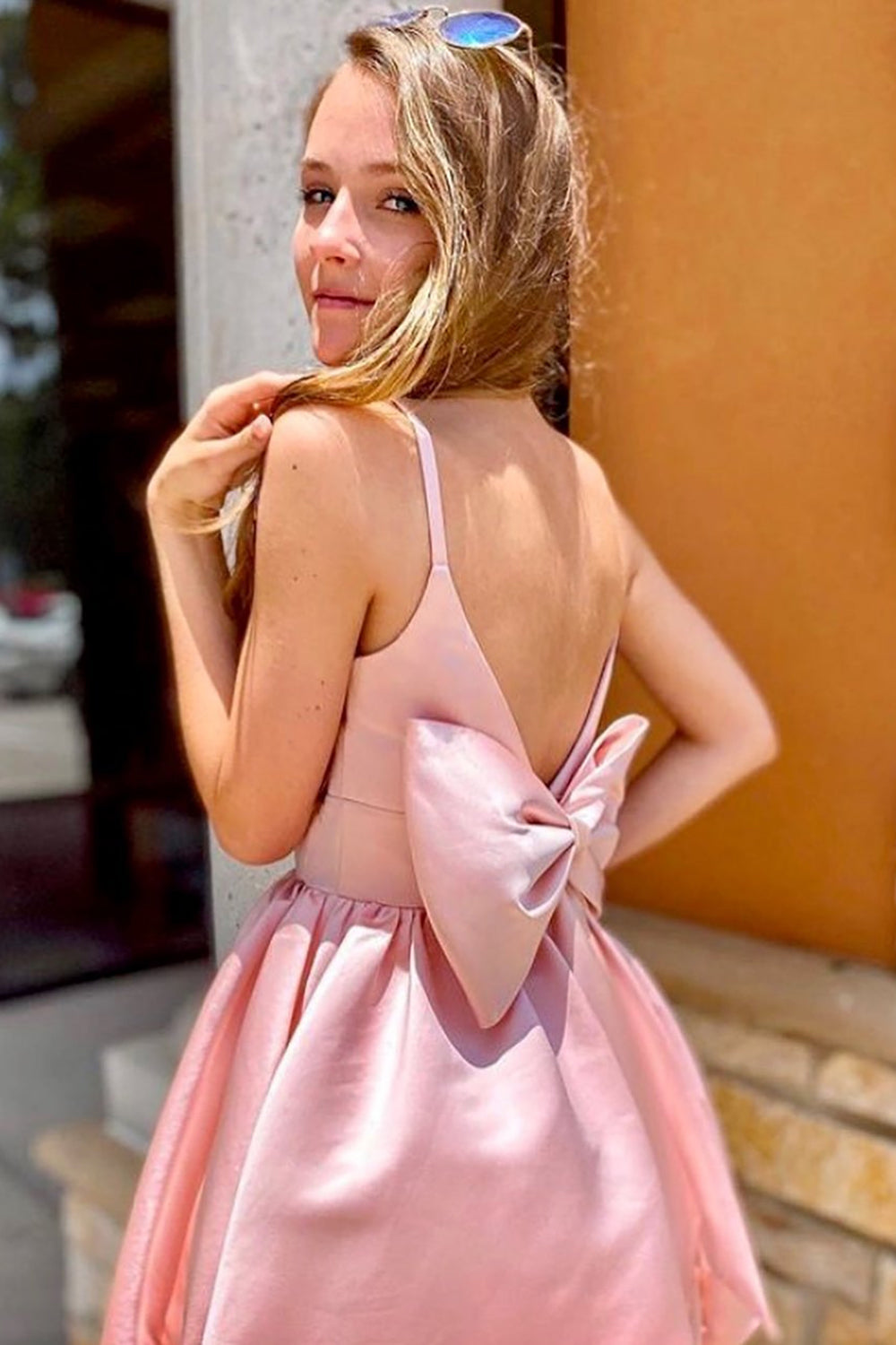 Side view of a model in the elegant pink A-line spaghetti strap homecoming dress.