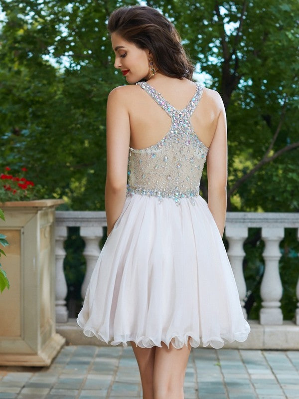 Close-up of rhinestone straps and V-neck on a short chiffon party dress.