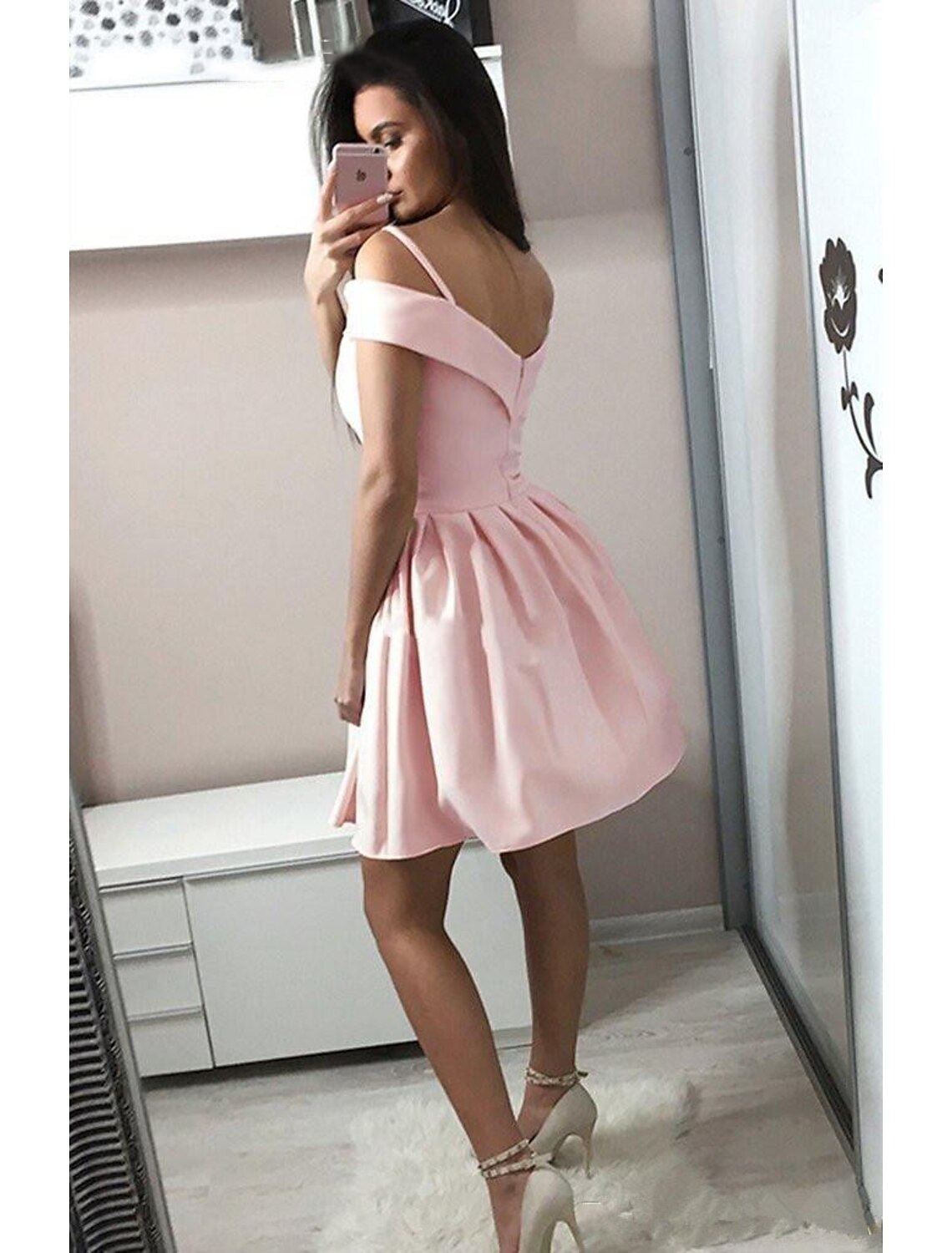 Side view of a model in a pink A-line V-neck knee-length party dress.