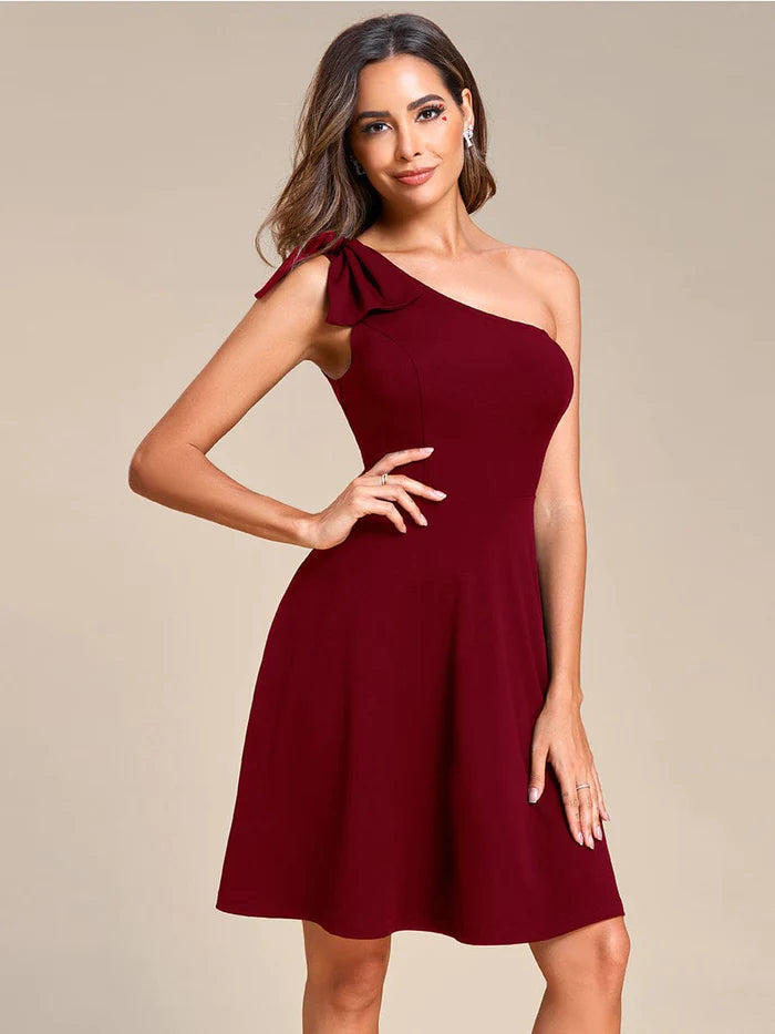 Model wearing a green Weitese one-shoulder mini dress with a bowknot, front view.