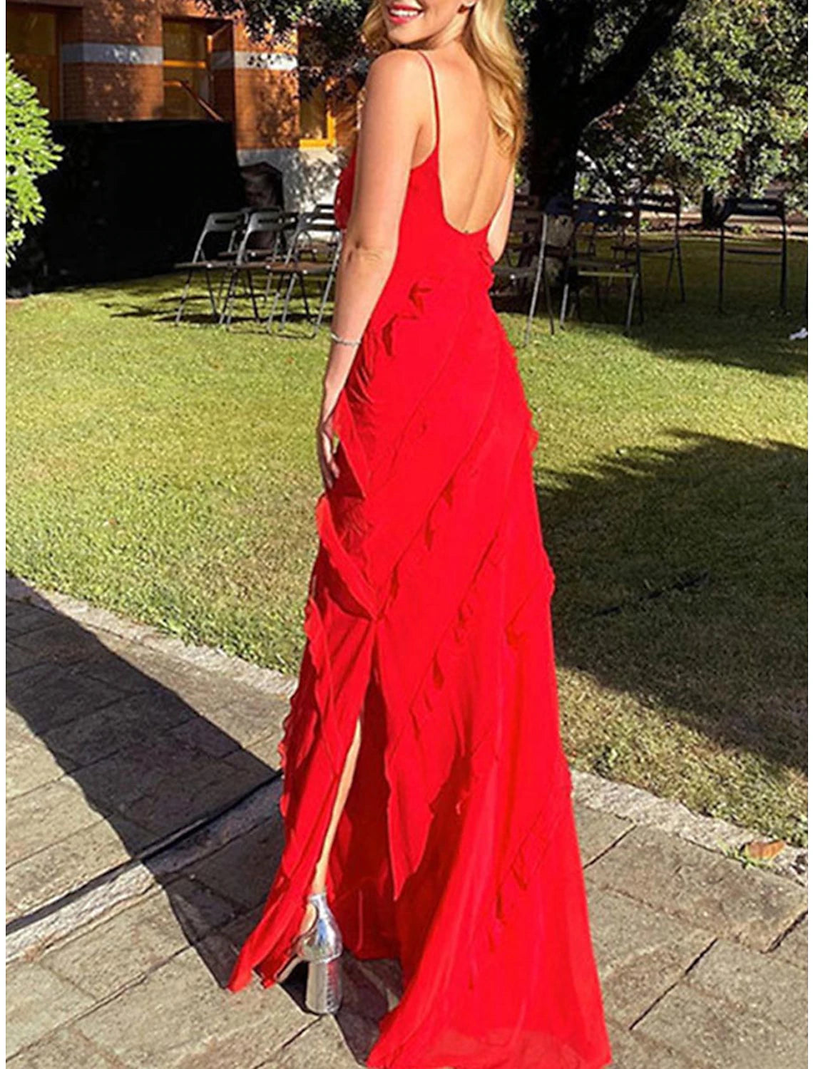 Woman wearing a red sleeveless maxi dress with spaghetti straps and ruffle detail.