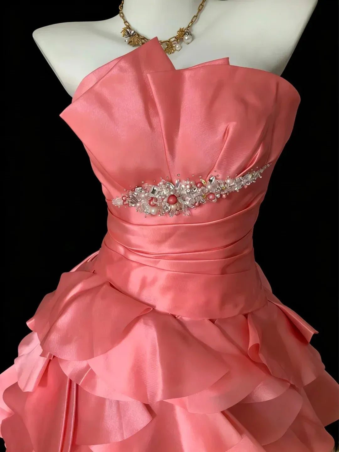 Close-up of the coral pink ball gown bodice, featuring a sweetheart neckline and sparkling rhinestone detail.