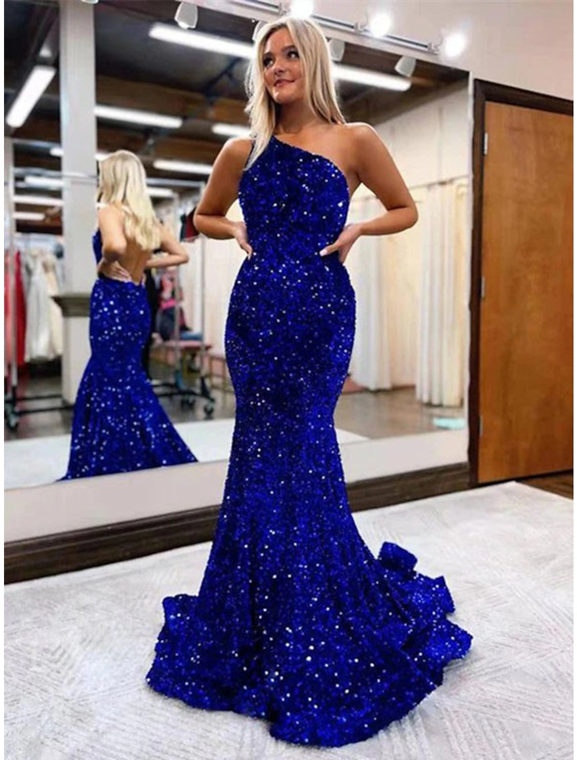 Woman wearing a dazzling one-shoulder sequined mermaid trumpet prom dress with a backless design.