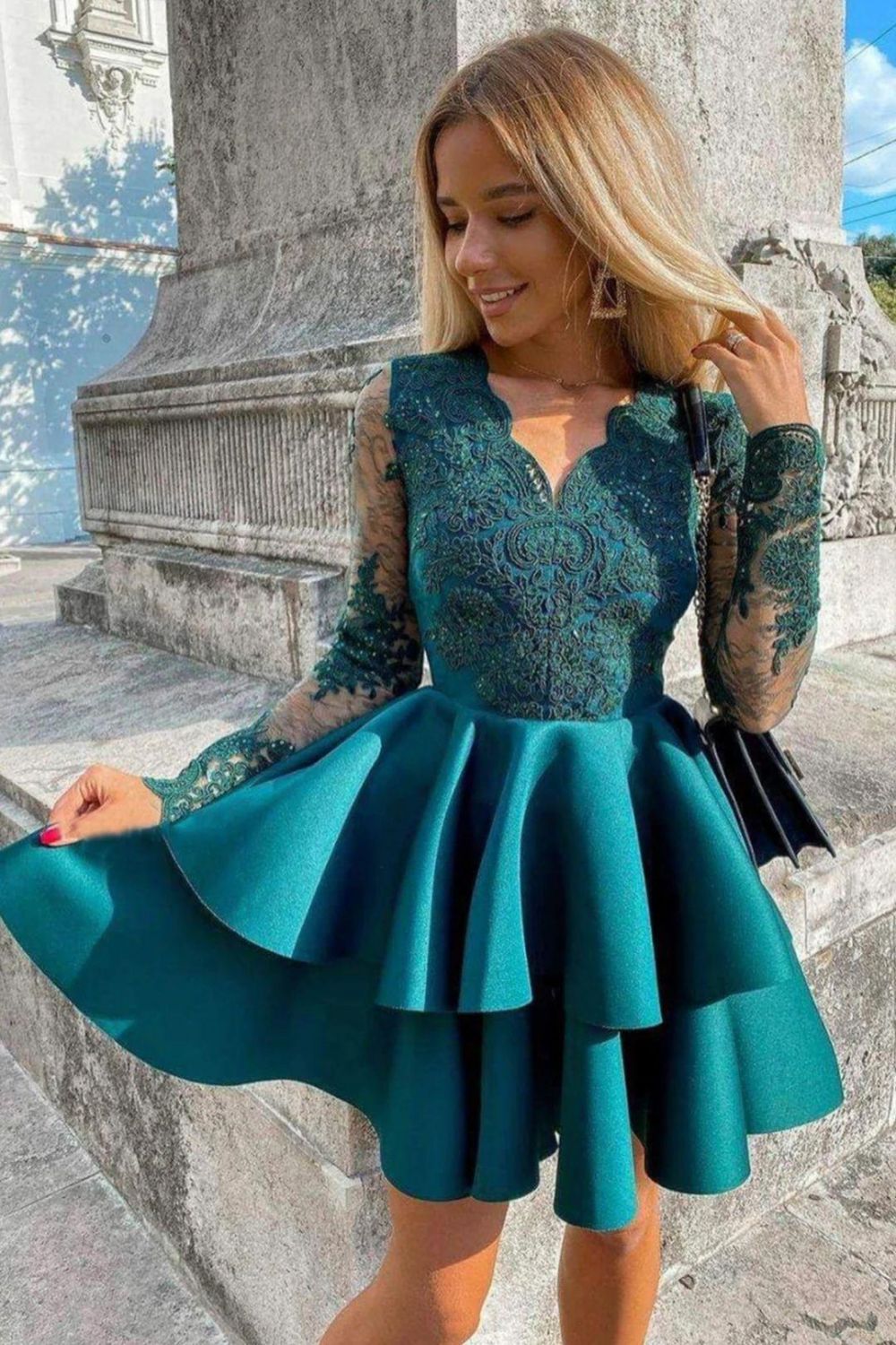 Model wearing a shimmering peacock A-line long sleeve sequined homecoming dress.