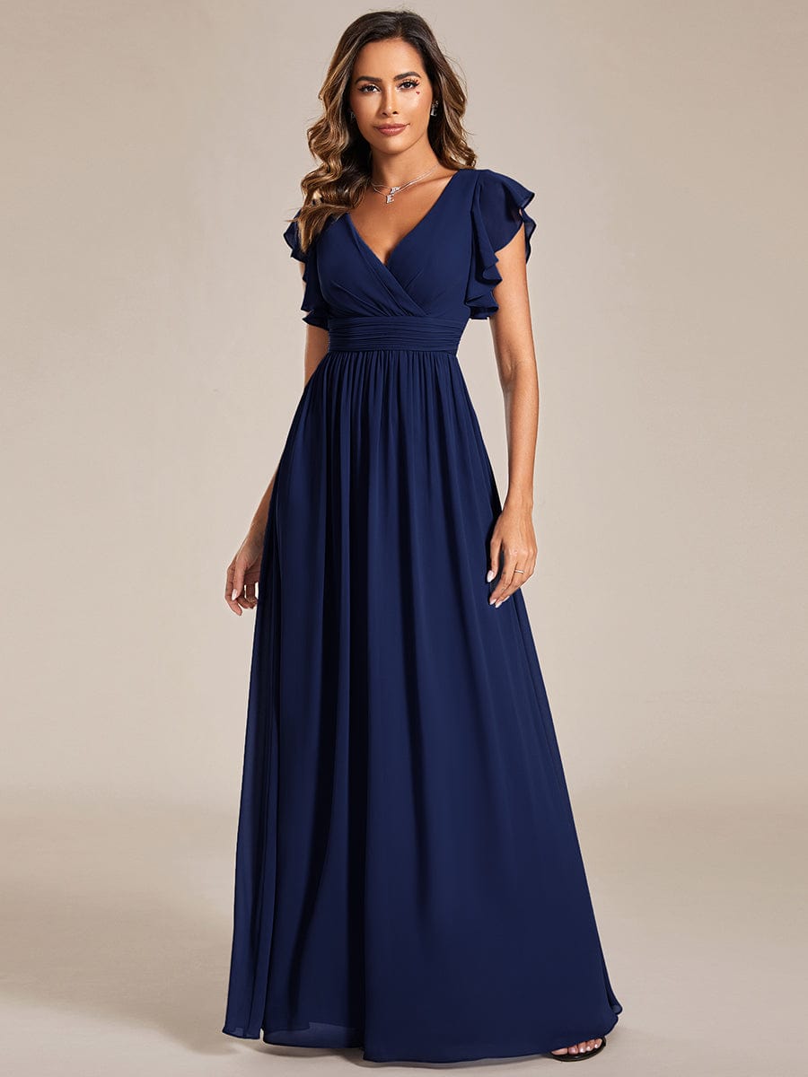 Model in a navy blue A-line chiffon bridesmaid dress, showcasing the elegant back cutout.