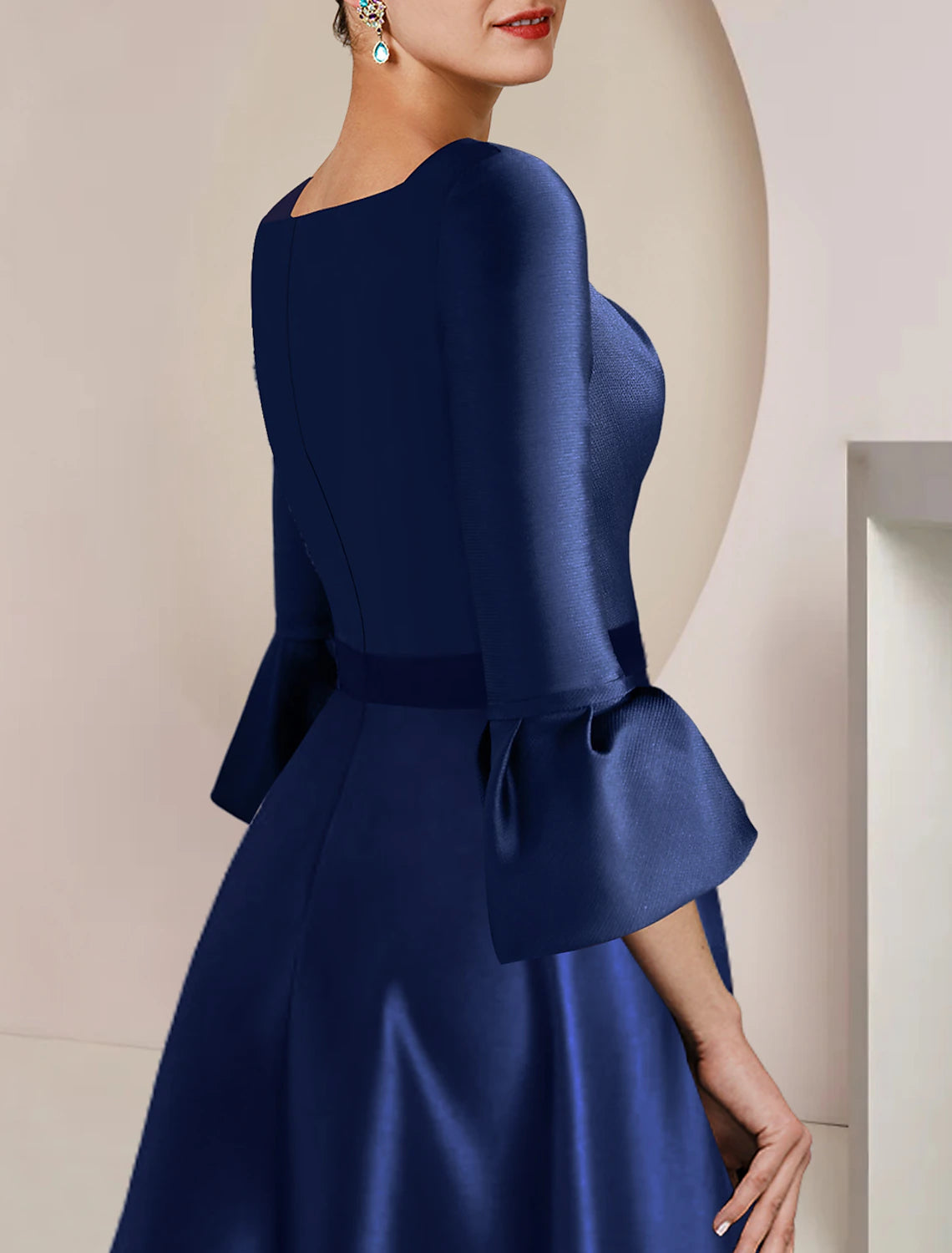 Close-up of the bateau neckline and 3/4 sleeves on the satin dress.