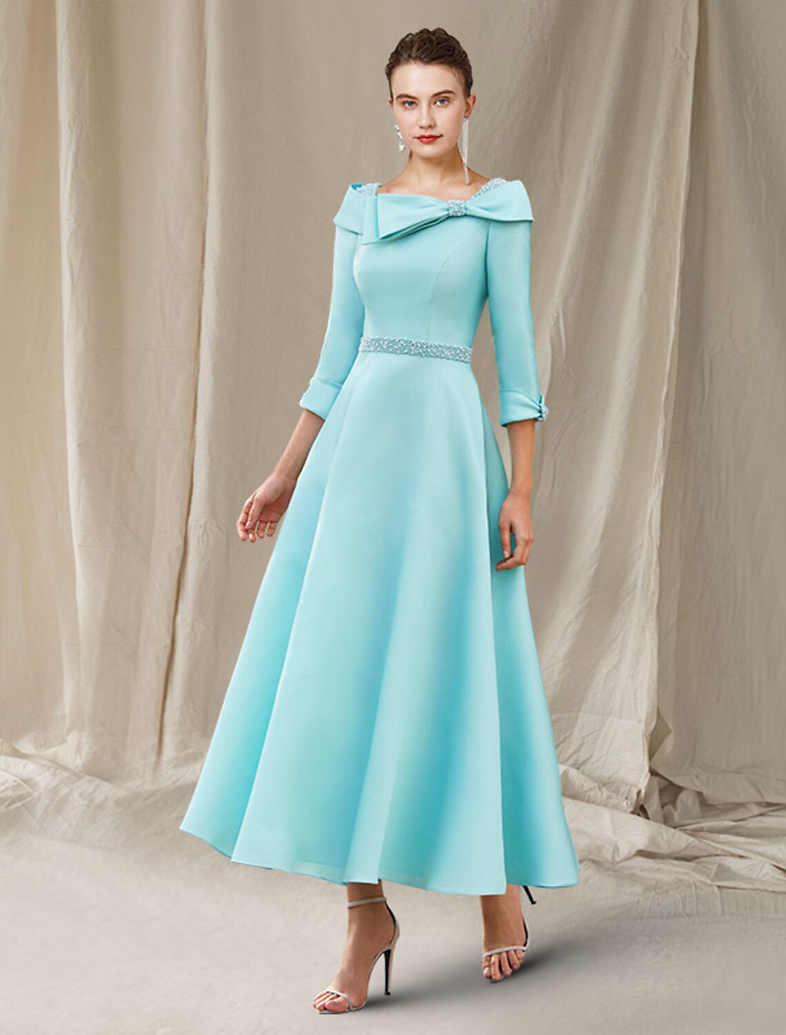 Elegant A-Line Mother of the Bride dress with bateau neck, 3/4 sleeves, and beading.