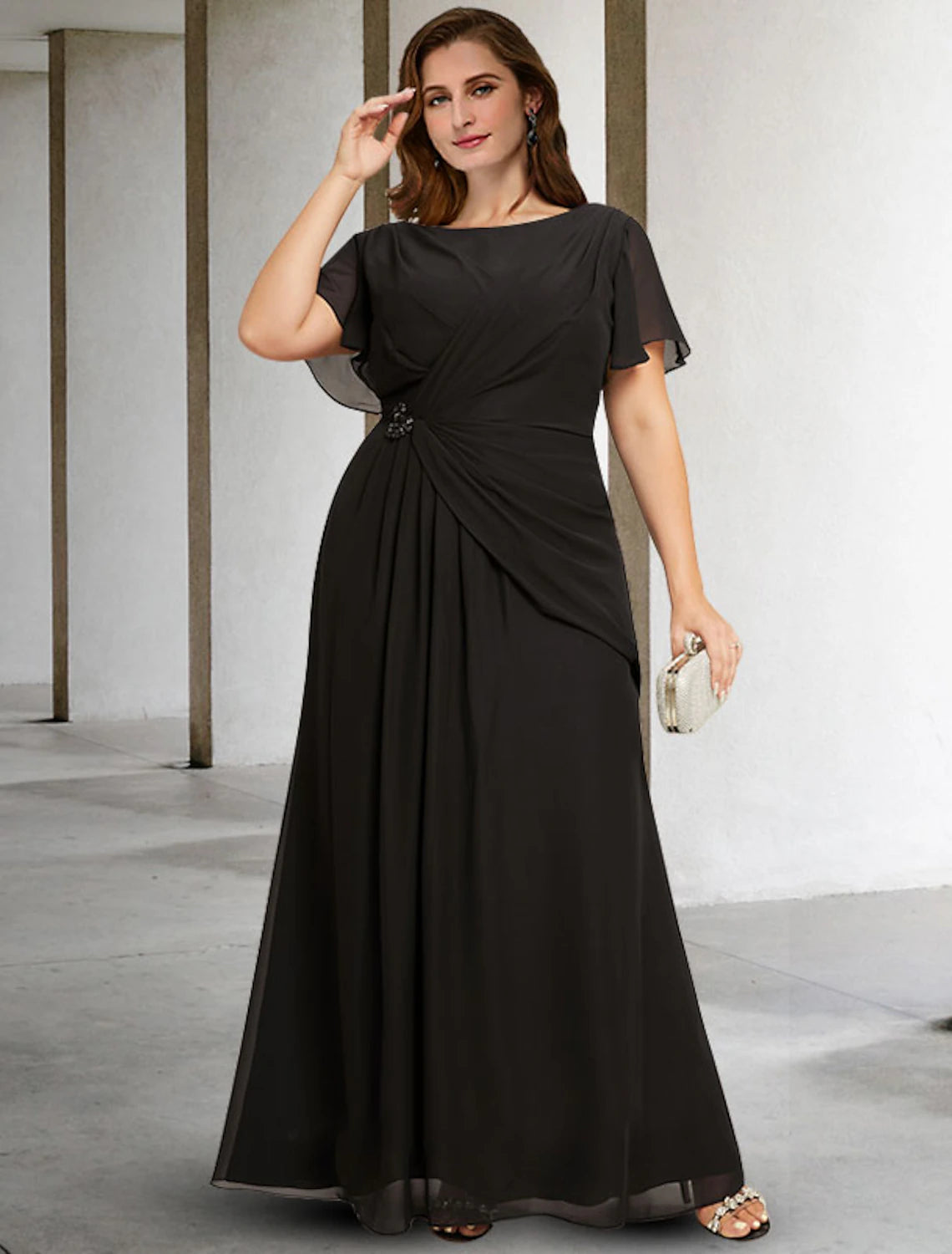 Plus size Mother of the Bride in an elegant dark blue A-line chiffon gown with ruched details.