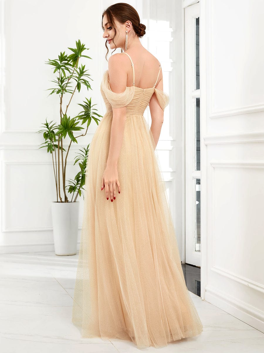 Model in a gold Weitese cold shoulder sequin tulle bridesmaid dress, side view.