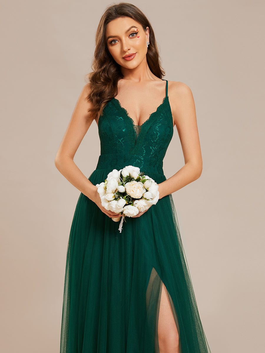 Back view of the dark green A-line tulle bridesmaid dress, highlighting the elegant cross-back spaghetti straps.