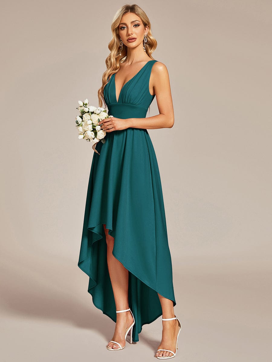 Model wearing a teal A-line deep V-neck high-low wedding guest dress, posing elegantly.
