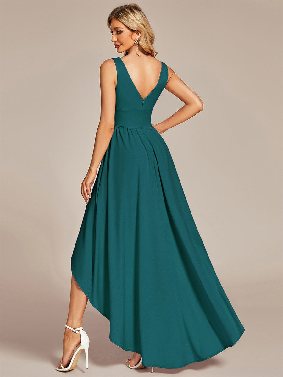 Model in a teal A-line deep V-neck dress, showing the back detail and high-low hem.