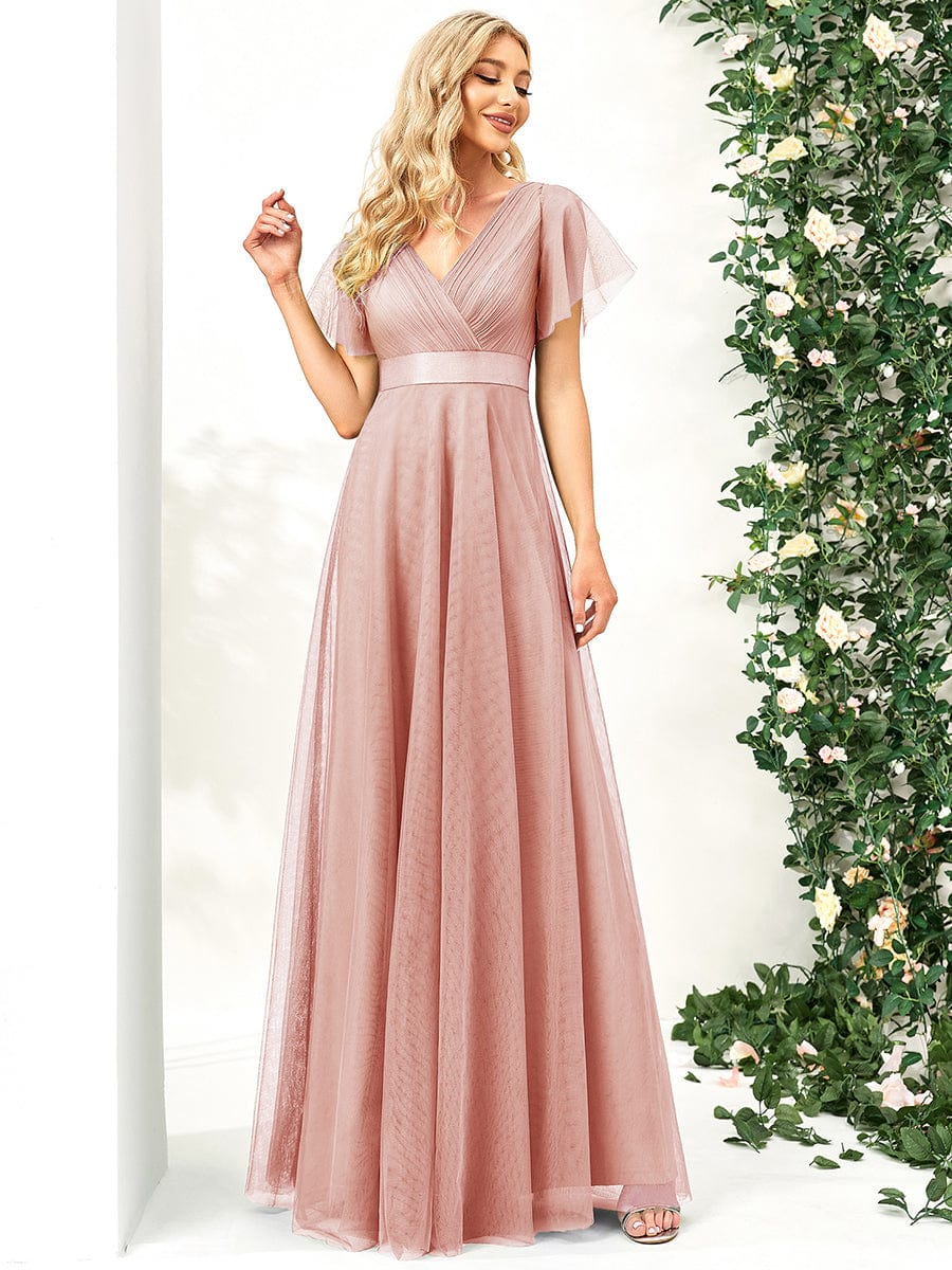 Close-up of the double V-neckline and short sleeves on a pink dress.