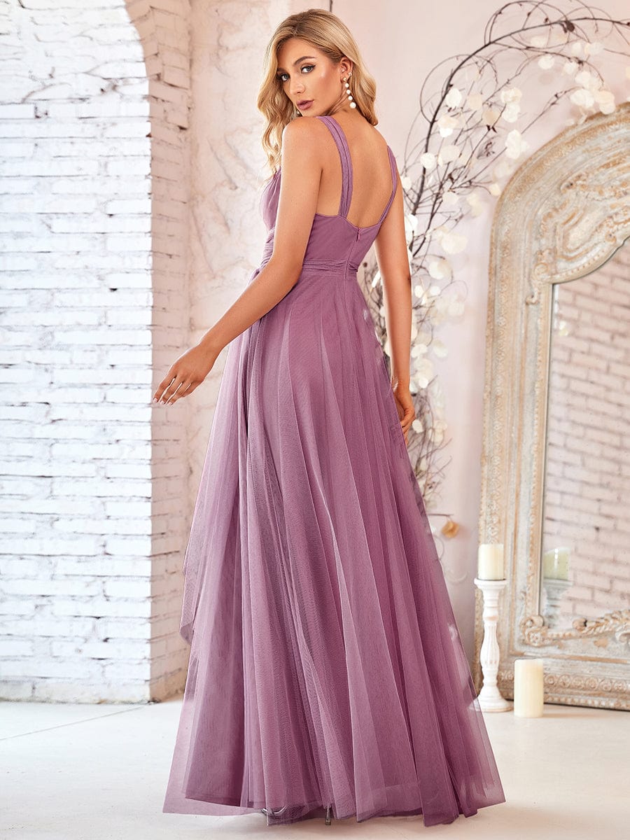 Back view of a model wearing a dark double V-neck tulle bridesmaid dress.