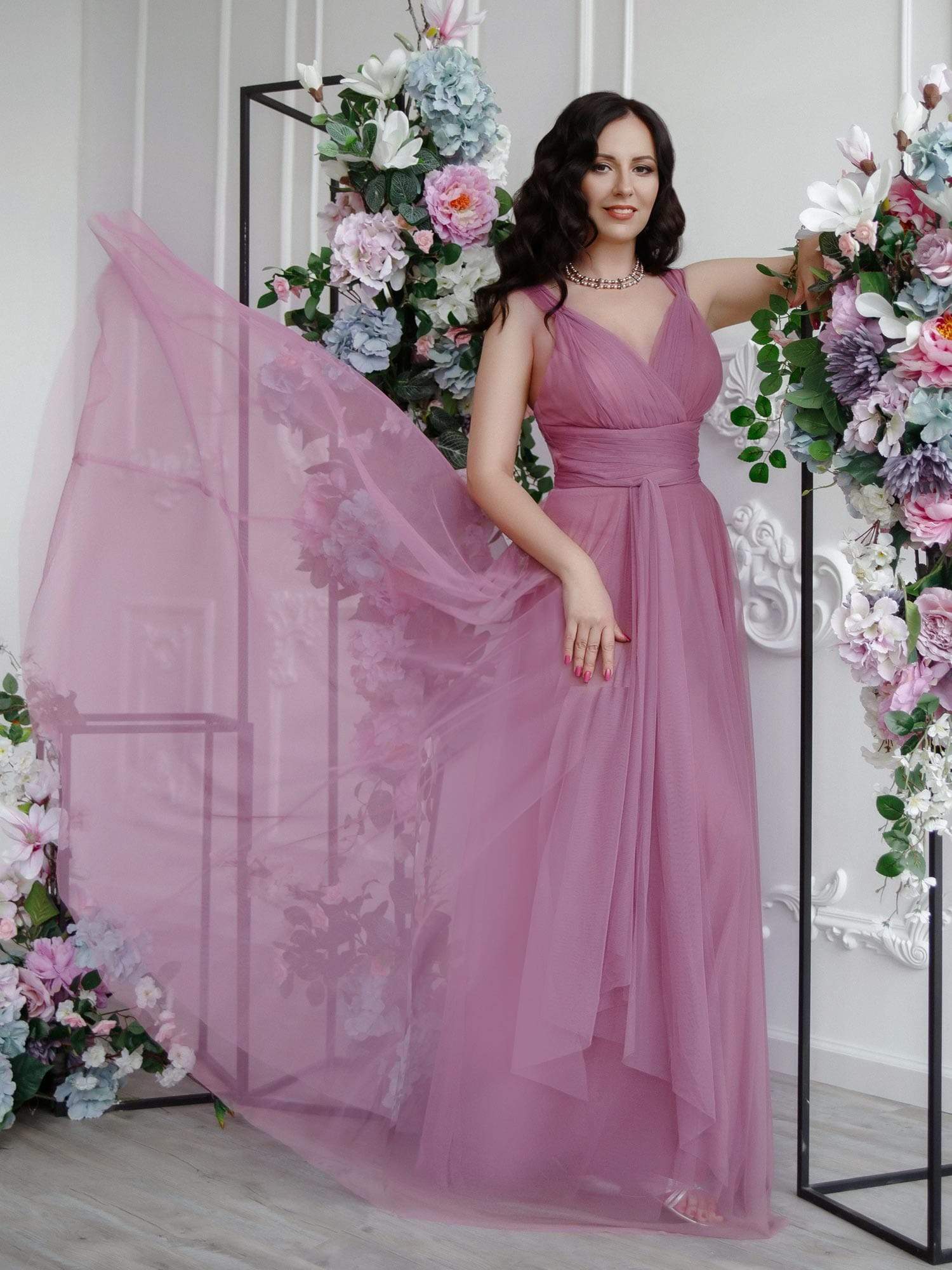 Model wearing a dark floor-length double V-neck tulle bridesmaid dress.