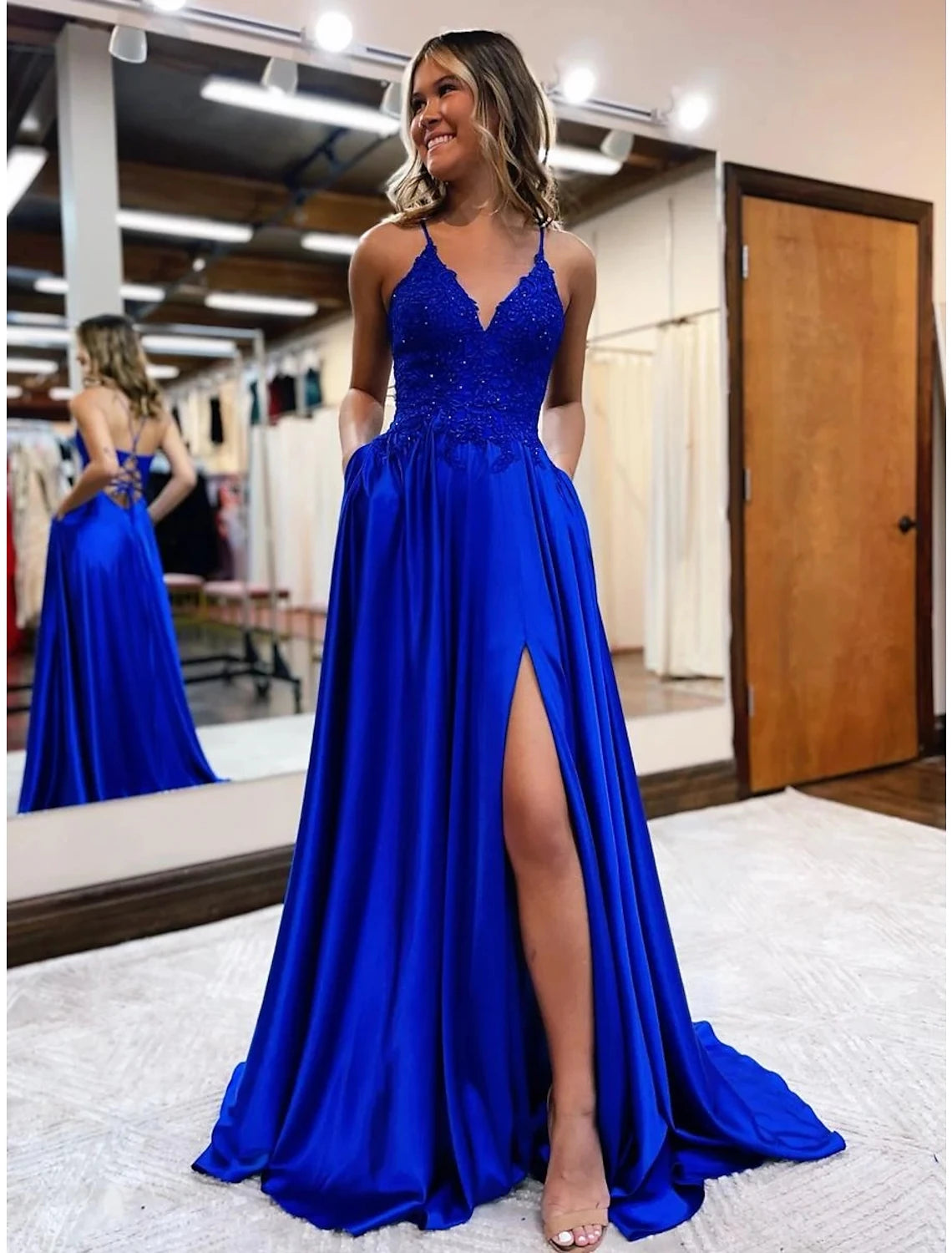 Model wearing an elegant A-line empire prom dress with V-neck, beading, and court train.