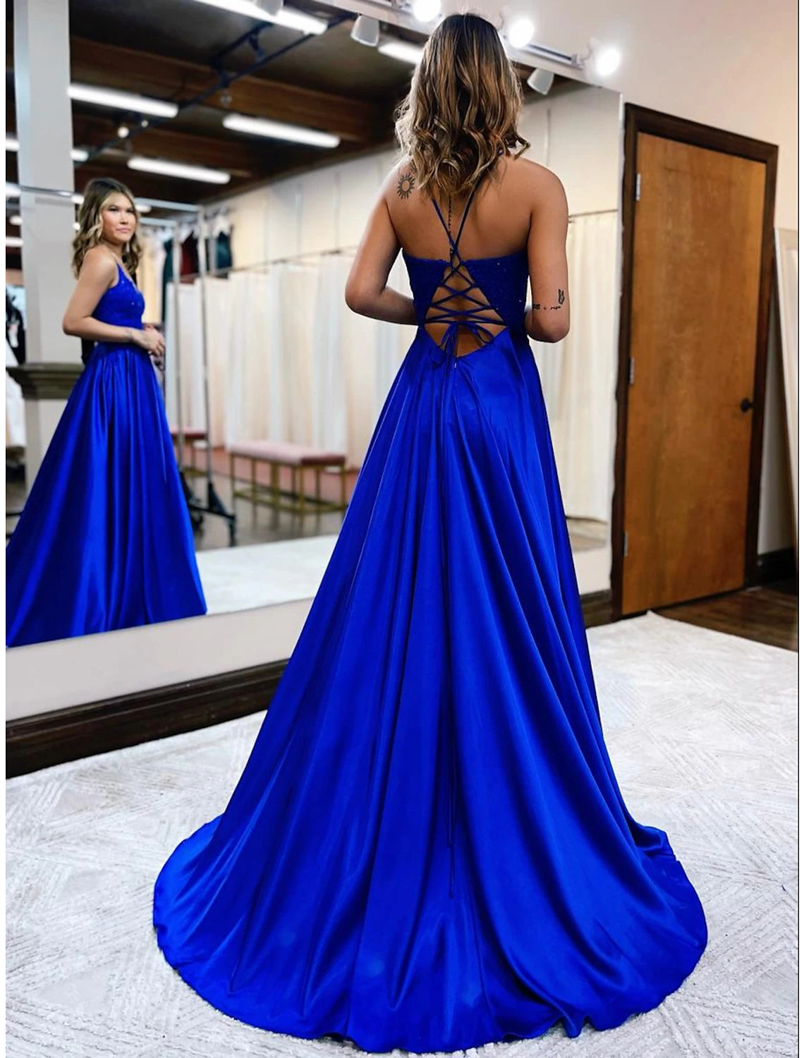 Back view of the A-line empire satin prom dress, highlighting the backless design and court train.
