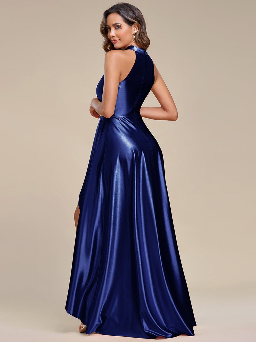 Back view of a model in a navy blue A-line halter high-low satin dress.