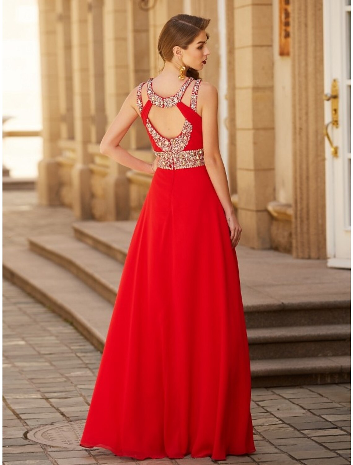 Back view of a model in a dark A-line halter neck chiffon gown, showcasing the flowing fabric.