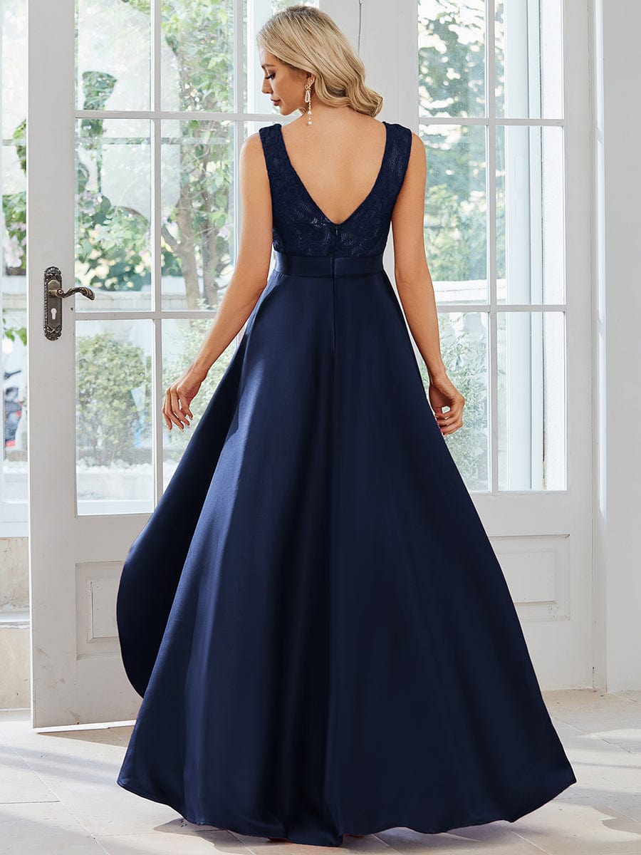 Back view of a model in a navy blue high-low lace top dress.