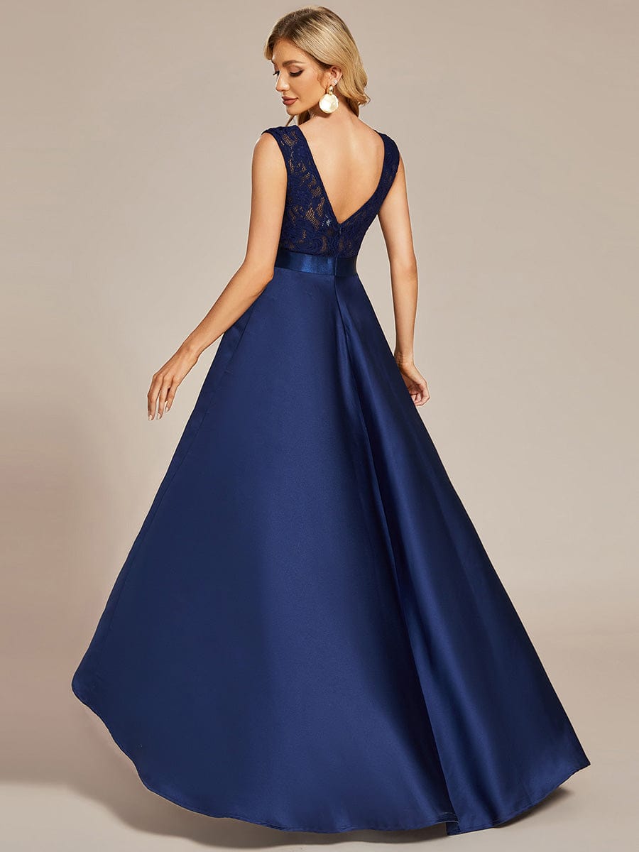 Model gracefully posing in a navy blue high-low lace dress.