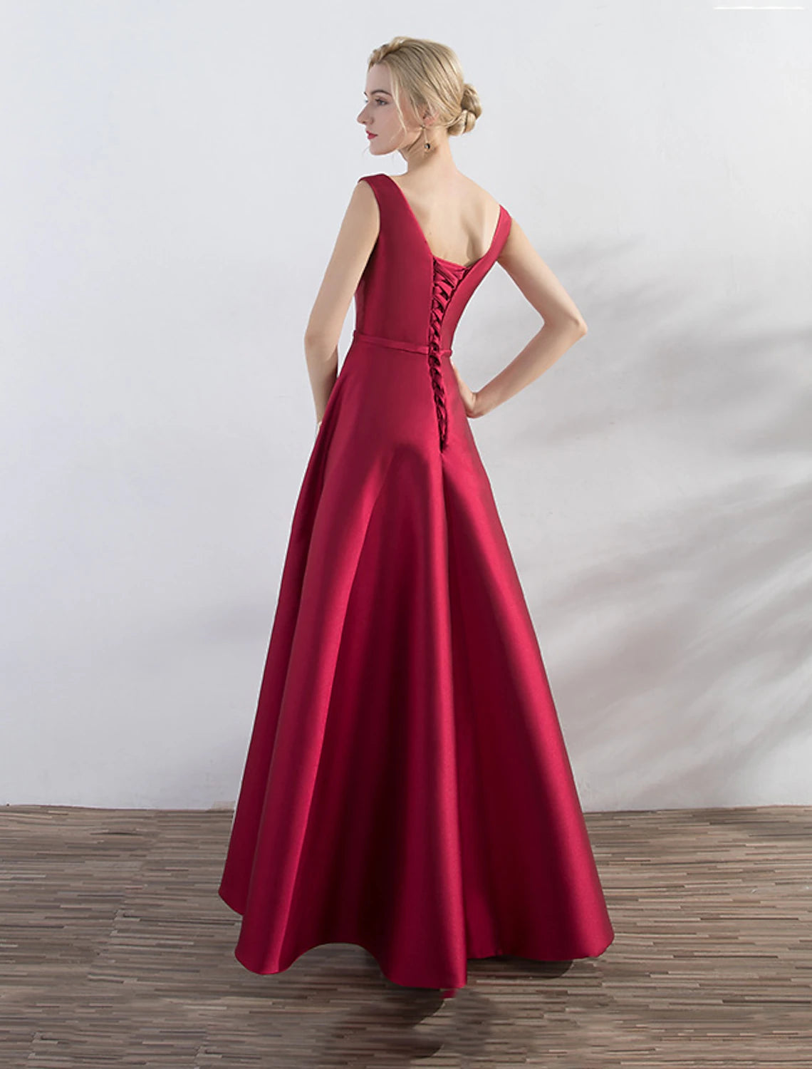 Side view of the red and green A-line evening gown, showcasing the luxurious satin fabric.
