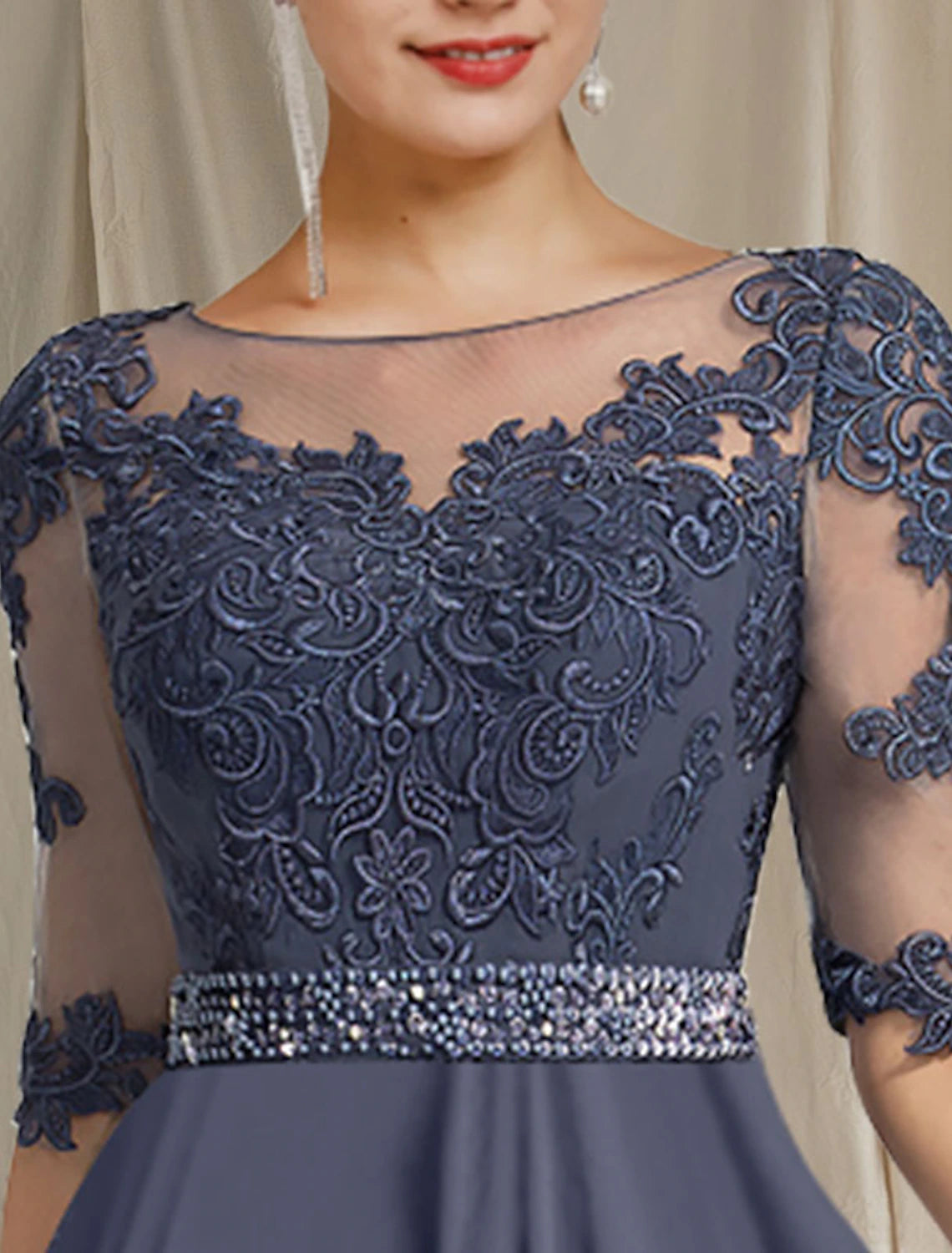 Close-up of the crystal appliques and lace detail on the half sleeve of the elegant dress.