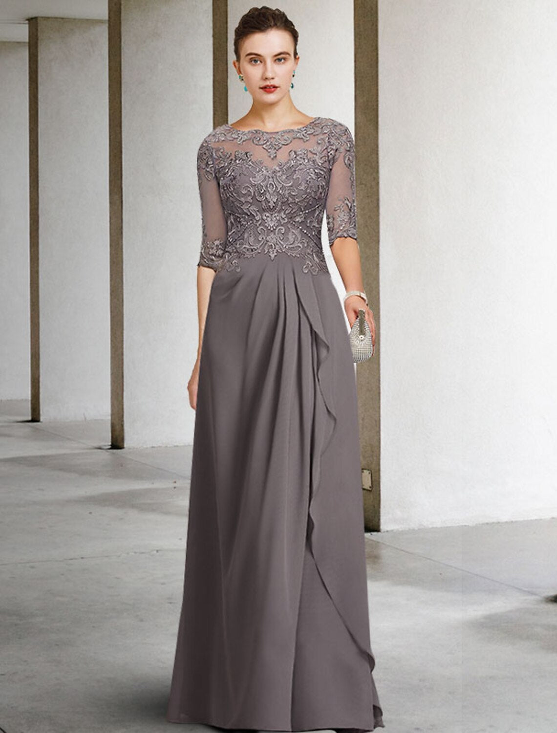 Woman wearing an elegant A-line Mother of the Bride dress with jewel neck and half sleeves.
