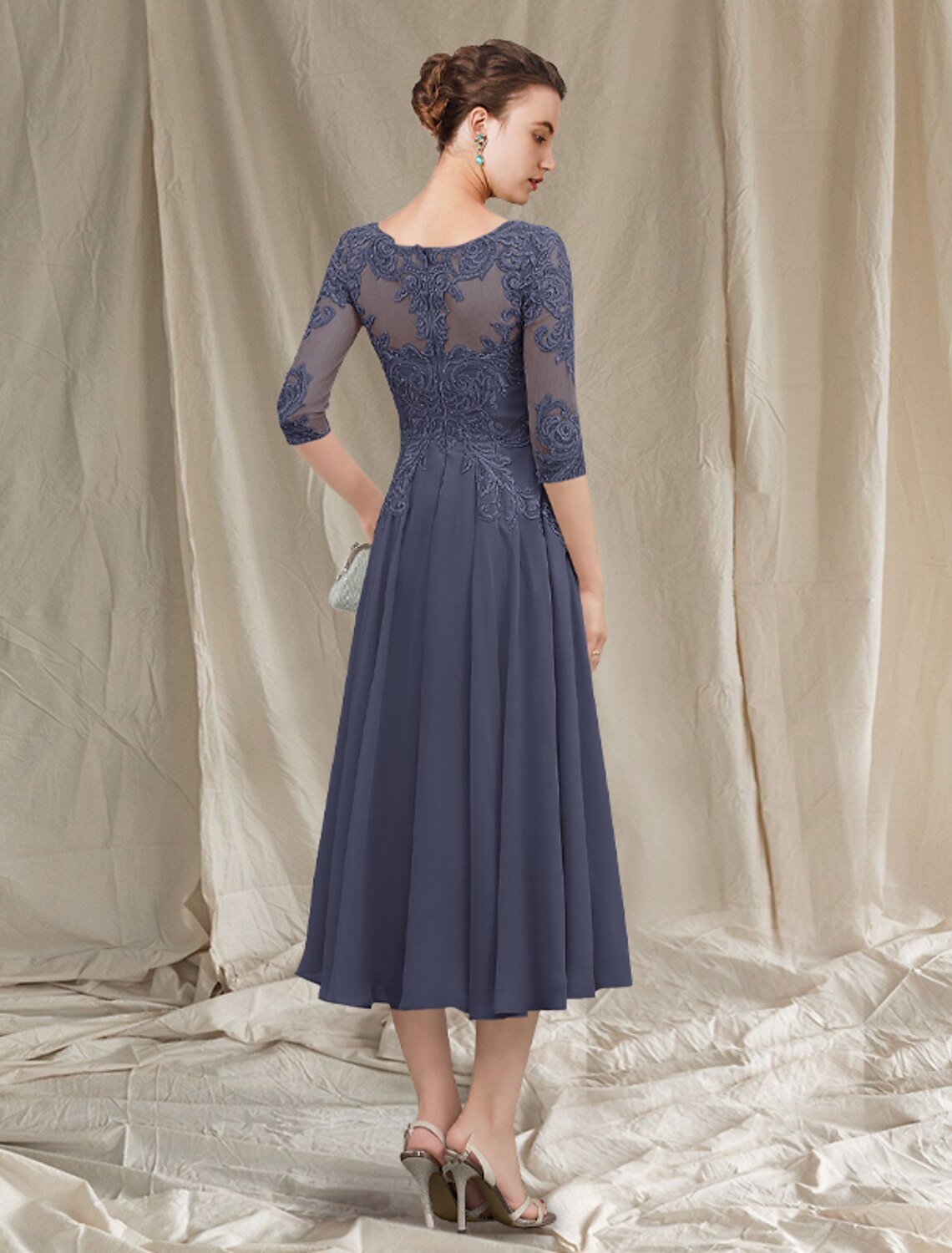Back view of A-Line Mother of the Bride dress, showing tea length, chiffon lace, and pleats.