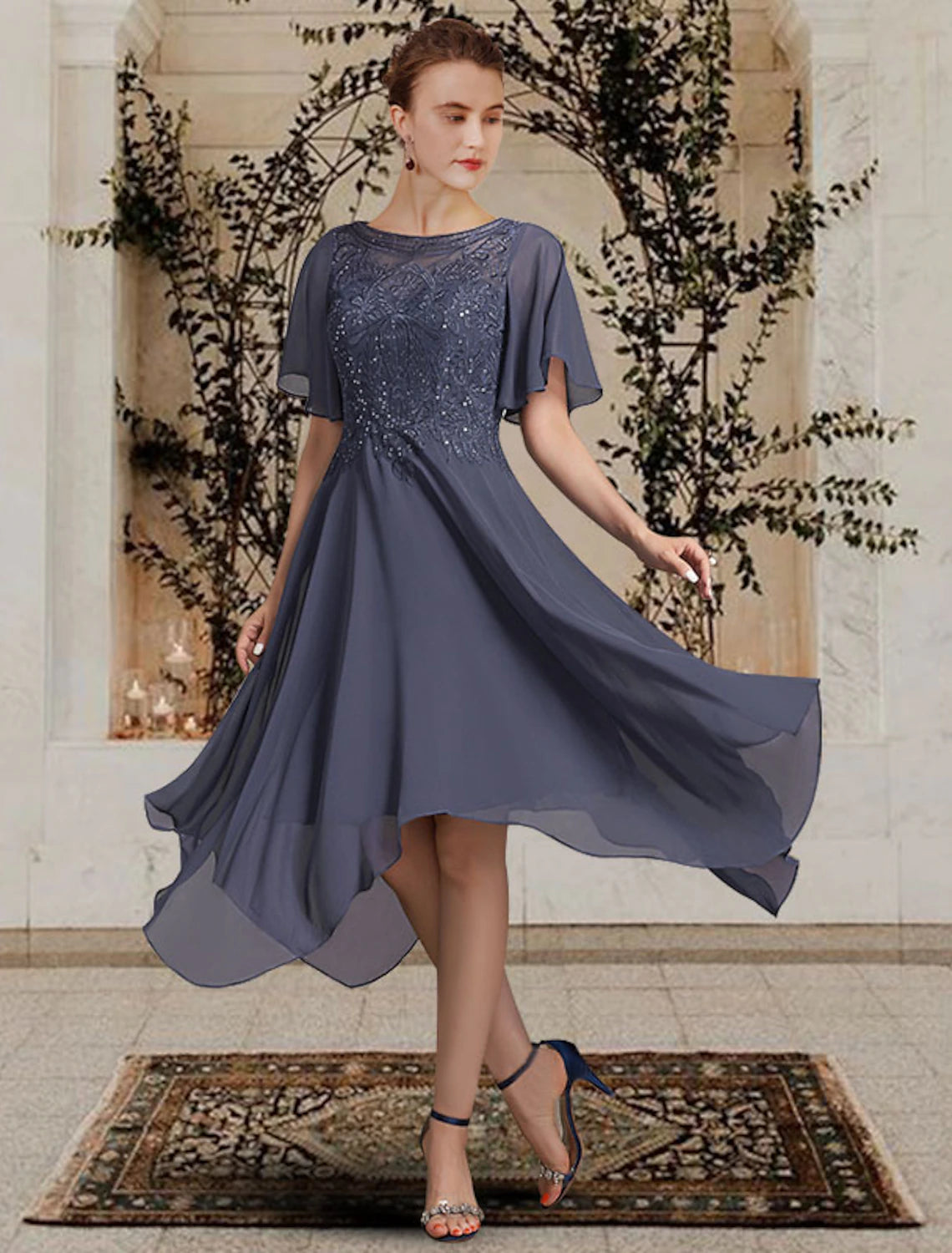 Side view of the elegant tea length mother of the bride dress with lace details.