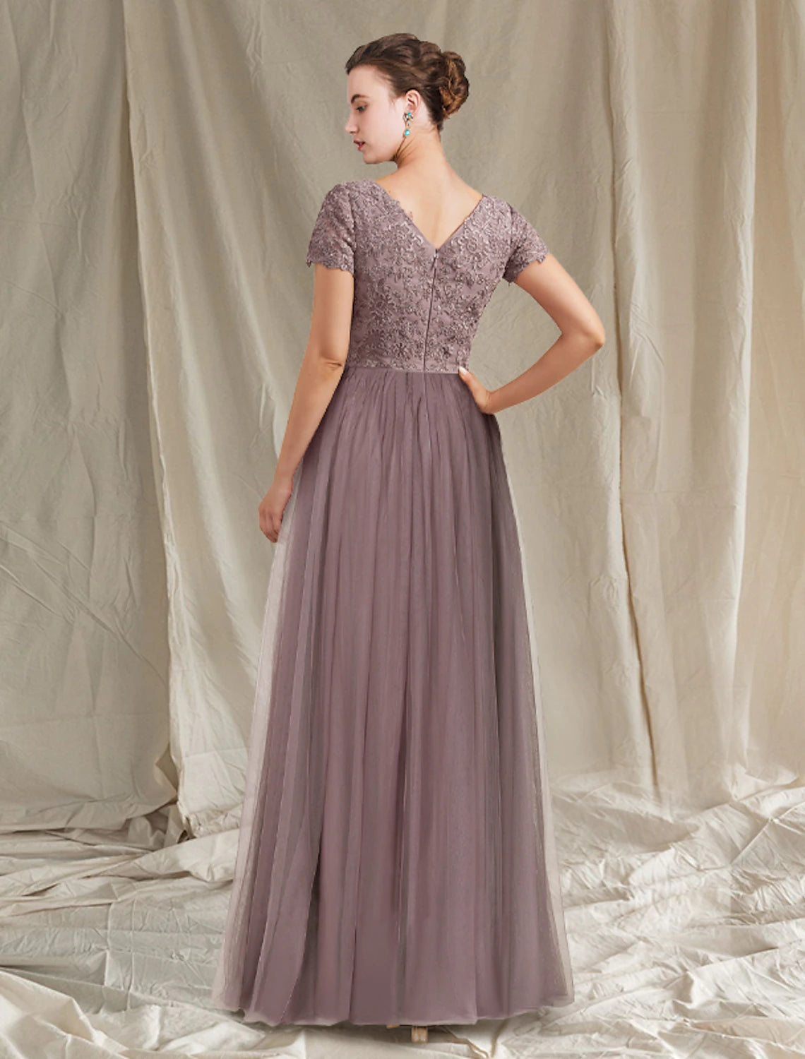 Close-up of lace tulle fabric and appliques on a floor-length gown.