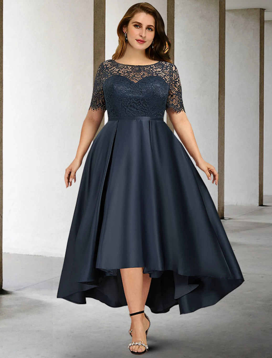 Woman wearing an elegant A-line jewel neck short sleeve pleated satin mother of the bride dress.