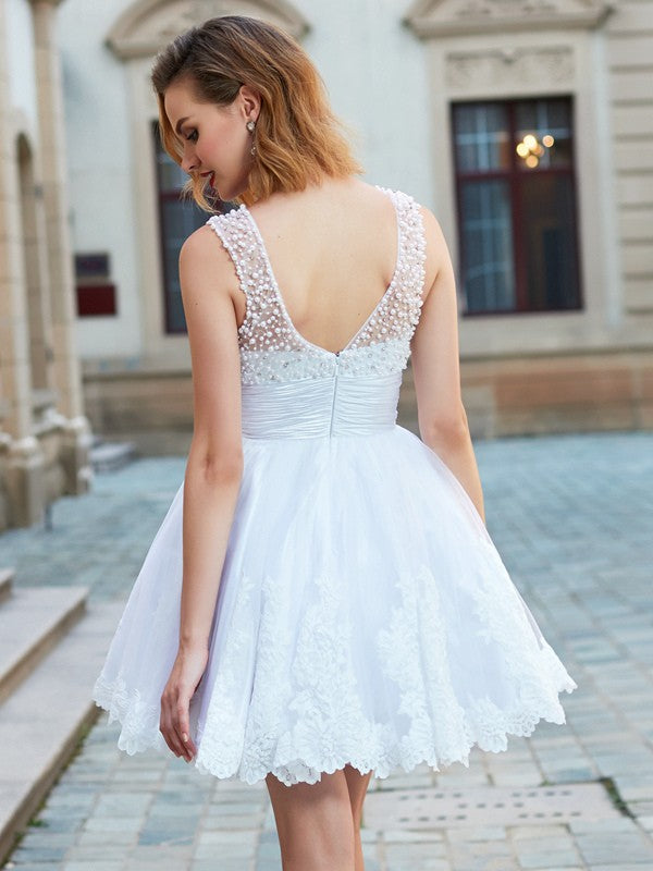 Woman in a sleeveless A-line pearl tulle mini dress, side view.