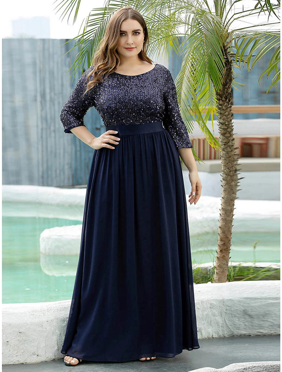Model wearing an elegant A-line sequined tulle dress with 3/4 sleeves.