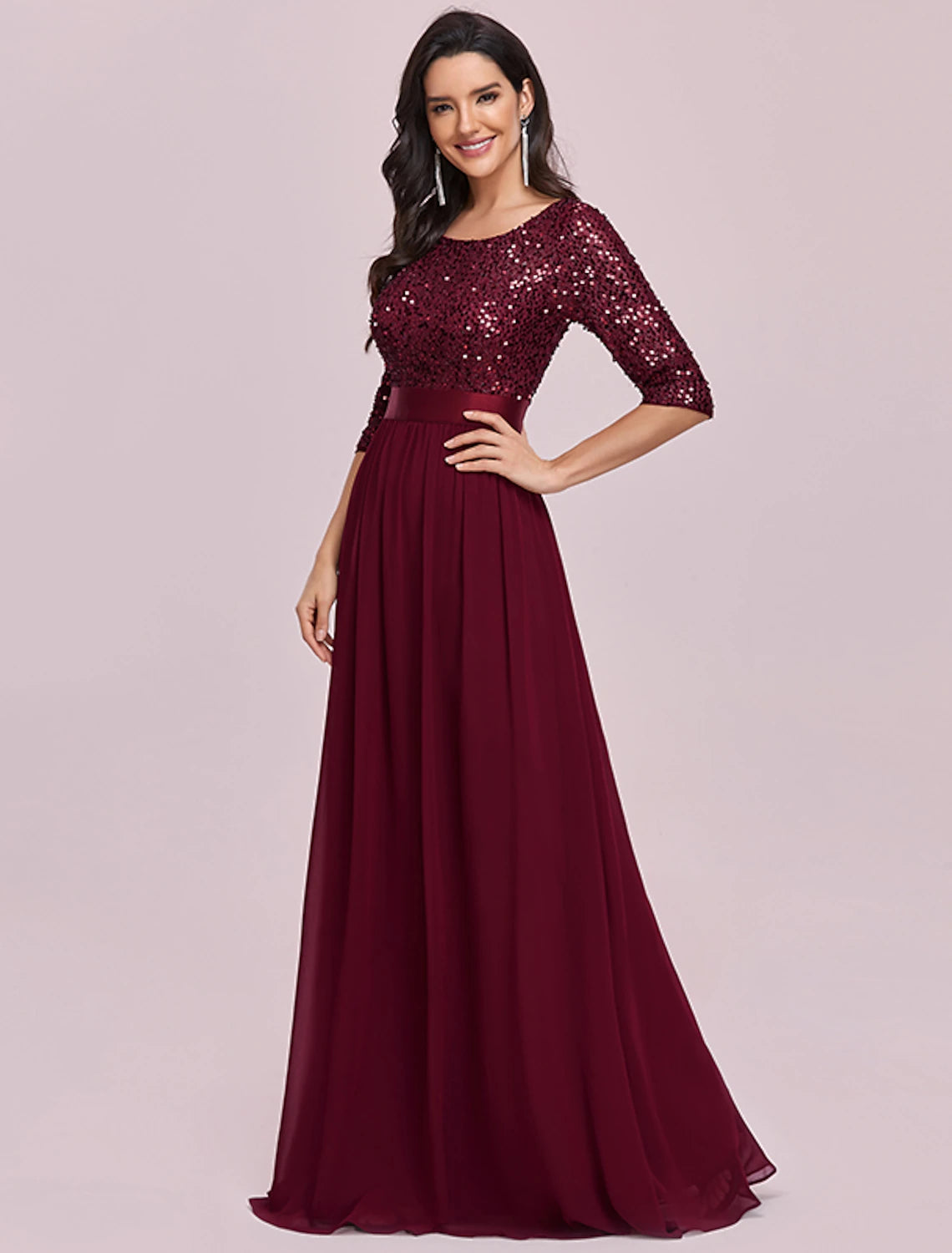 Model posing in the elegant plus-size wedding guest dress.