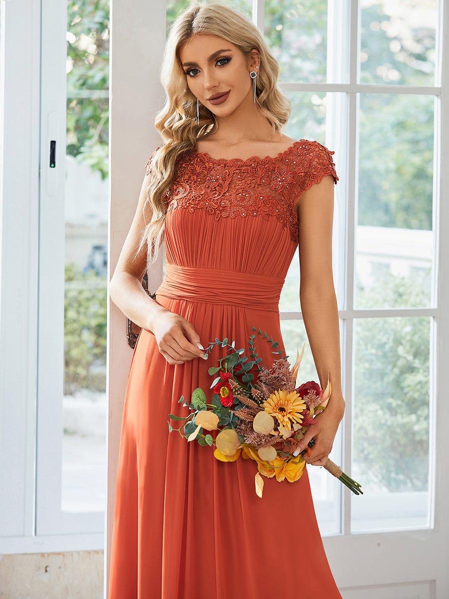 Back view of a floor-length blue bridesmaid dress with lace cap sleeves.