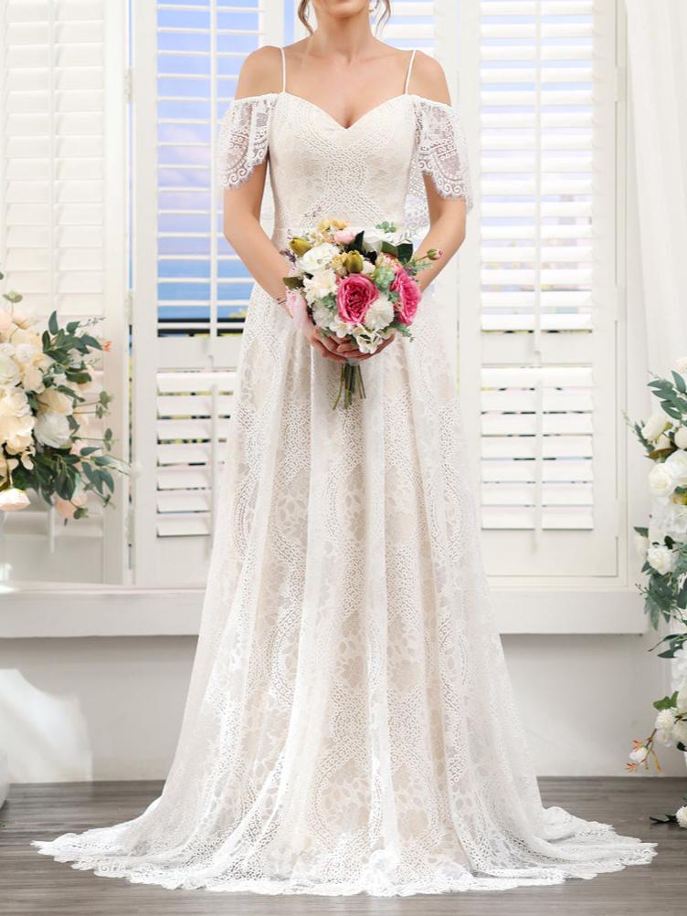 Bride in an elegant A-line lace wedding dress with spaghetti straps and short sleeves.