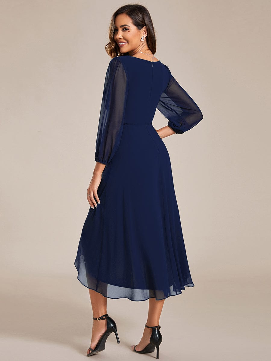 Model in a navy Weitese long sleeve midi dress, side view.