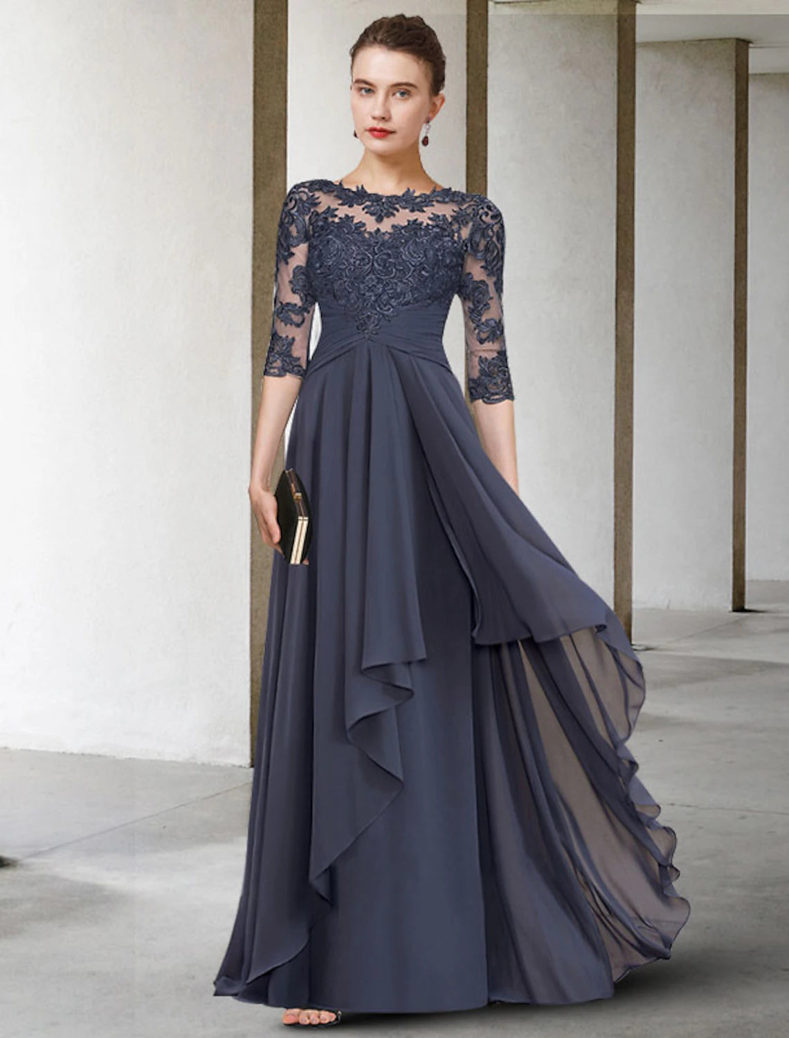 Woman wearing an elegant A-line mother of the bride dress with jewel neck and 3/4 sleeves.