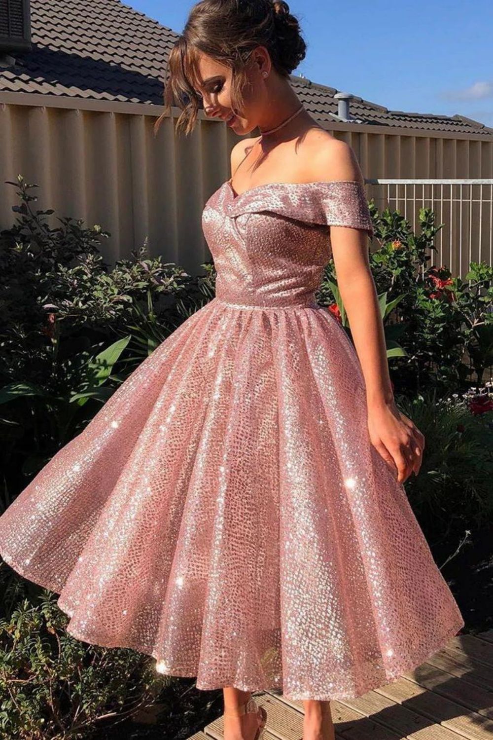 Model wearing a navy blue A-line off-the-shoulder glitter homecoming dress, posing elegantly.