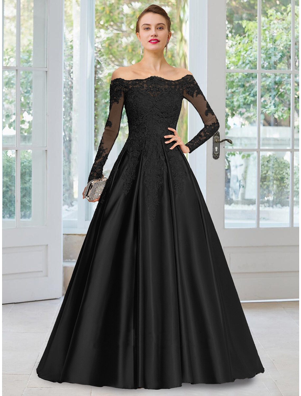 Woman wearing an elegant black A-line off-shoulder long-sleeve evening gown with floral lace and a court train.