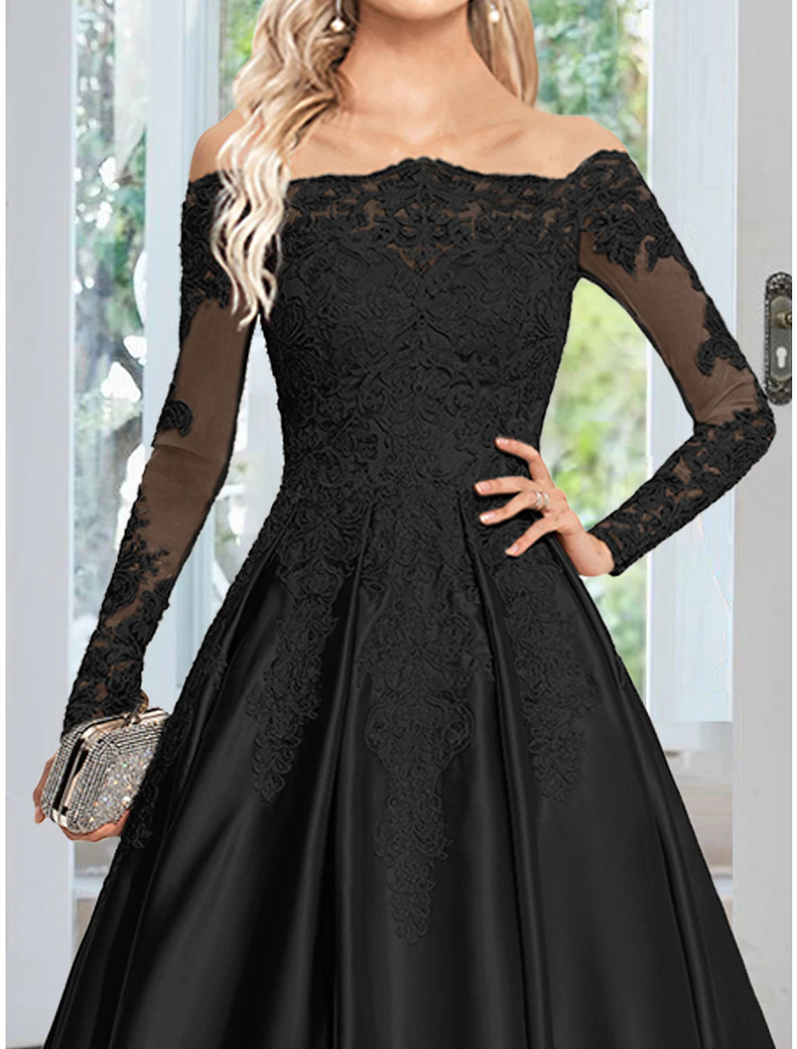 Close-up of the delicate appliques on the long sleeve of the satin evening gown.